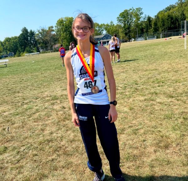 Ella Walsh showing off her cross country medal